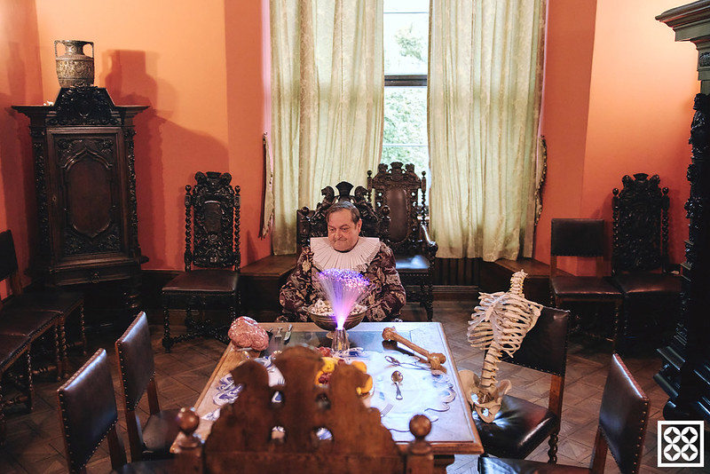 zdjęcie zabytkowego wnętrza gabinetu burmistrza. przy stole Mężczyza ubrany w strój z epoki