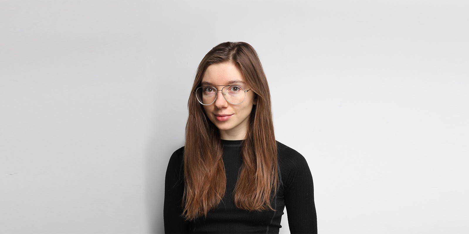 portret młodej kobiety, sługie włosy, okulary, ciemna bluzka