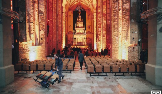 Widok na centrum św. jana - pracownicy roznoszą krzesła po nawie głównej