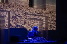 zdjęcie kobiety przy mikserze dźwięków, w tle wizualizacje