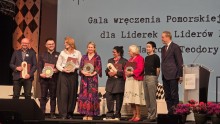zdjęcie ludzi na scenie statuetki, kwiatki