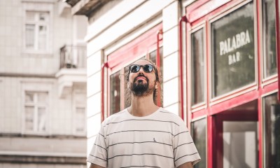 Muzyk Ciskco Pema stoi w pomieszczeniu. Na drugim planie wiszą obrazy. 13. Festiwal Kultur Okno na świat. 27 sierpnia 2023. Koncert w Centrum św. Jana