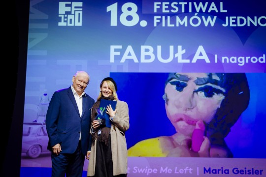 zdjęcie dwóch osób, kobiety i mężczyny, uśmiwchają się, trzymają nagrodę. W tle napis "I nagroda, fabuła"