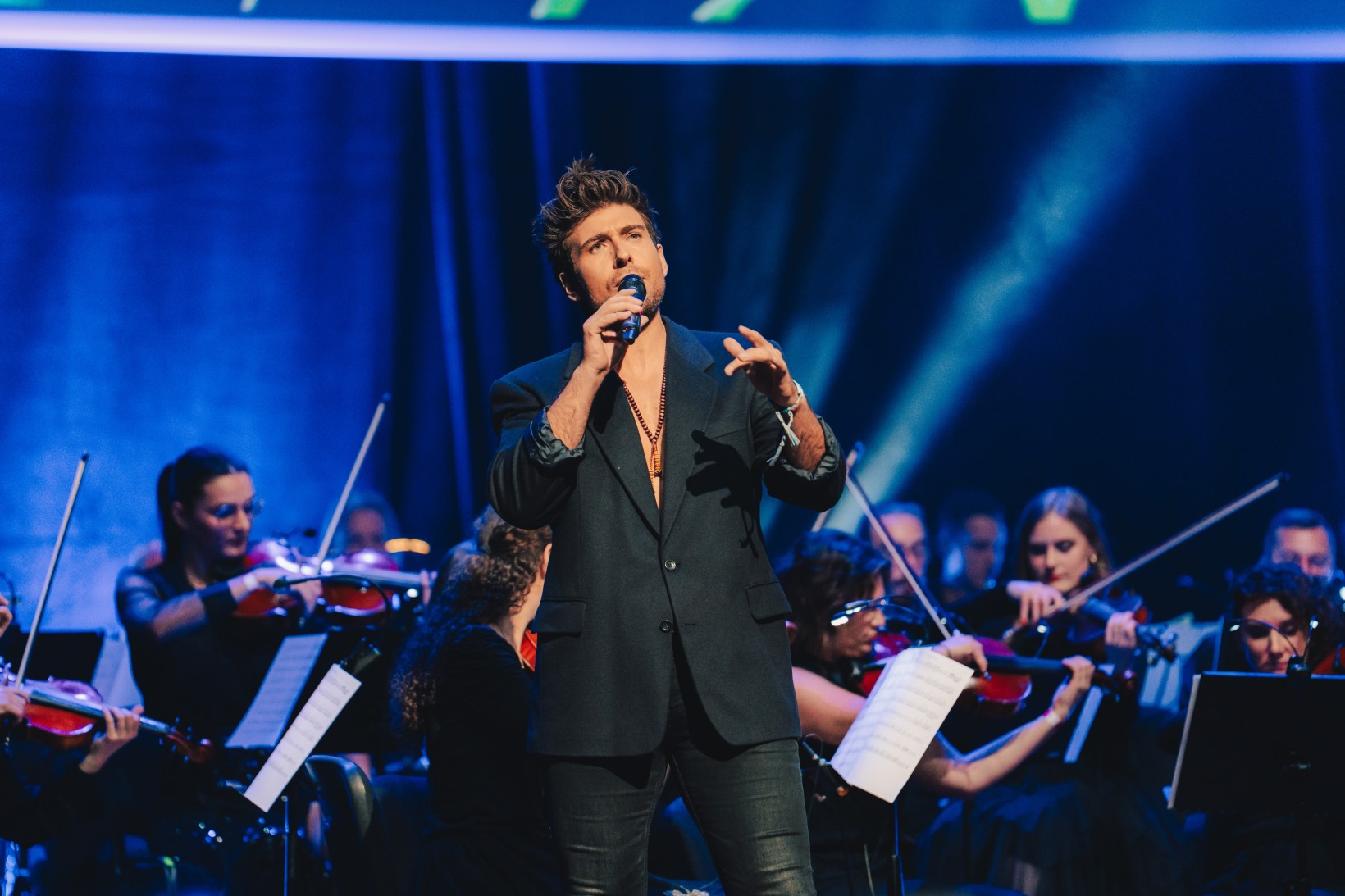zdjęcie, Michał Sołtan śpiewa, z tyłu gra orkiestra
