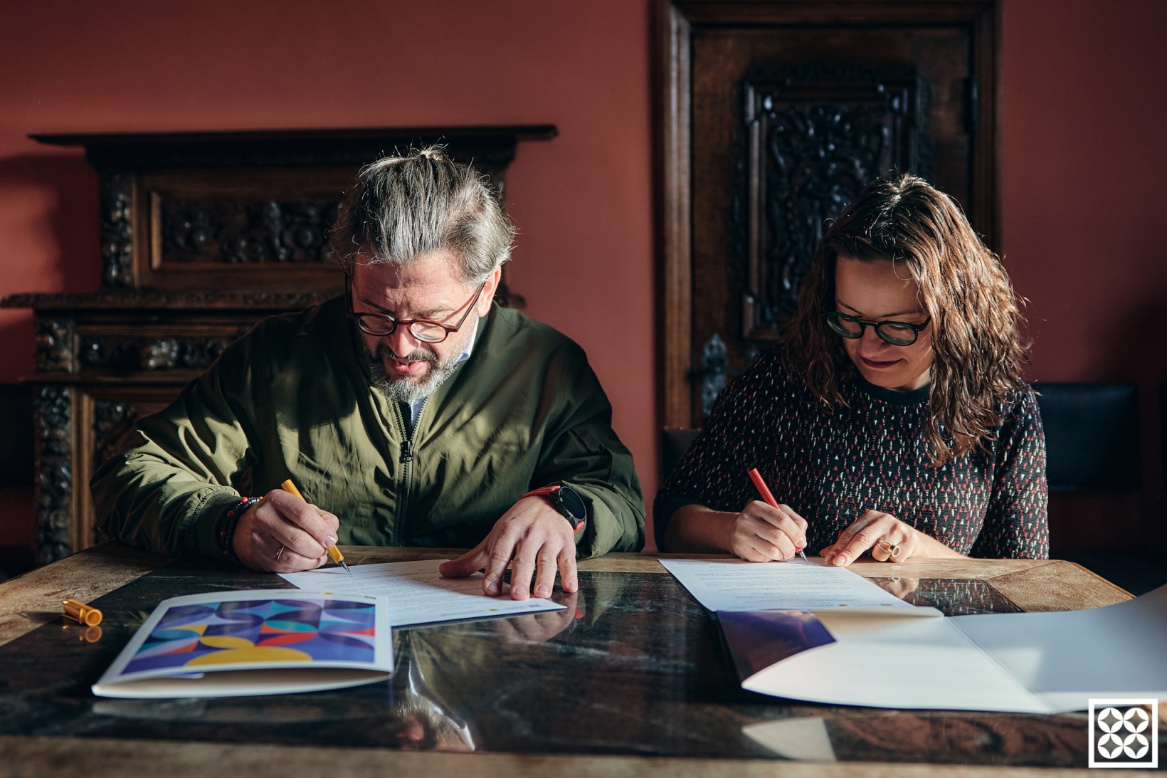 fotografia kobiety i mężczyzny podpisujących listy