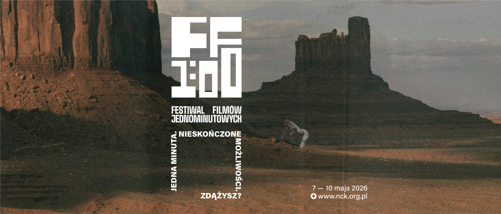 Plakat festiwalu filmowego na tle pustynnego krajobrazu z monumentalnymi formacjami skalnymi; na środku duży, stylizowany napis „FF 1:00” oraz tekst „Festiwal Filmów Jednominutowych”, a niżej hasło „Jedna minuta. Nieskończone możliwości. Zdasz?”; w prawym dolnym rogu widnieje data „7–10 maja 2026” i adres strony internetowej.